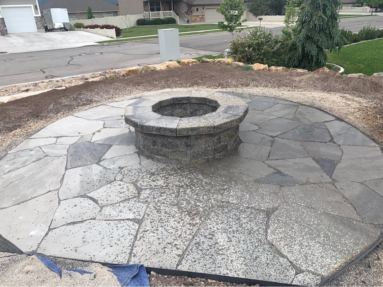 Round flagstone patio with a stone fire pit