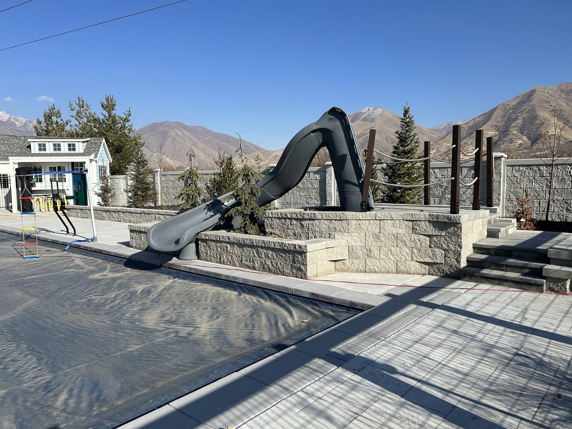 Pool slide and paver deck below the mountains