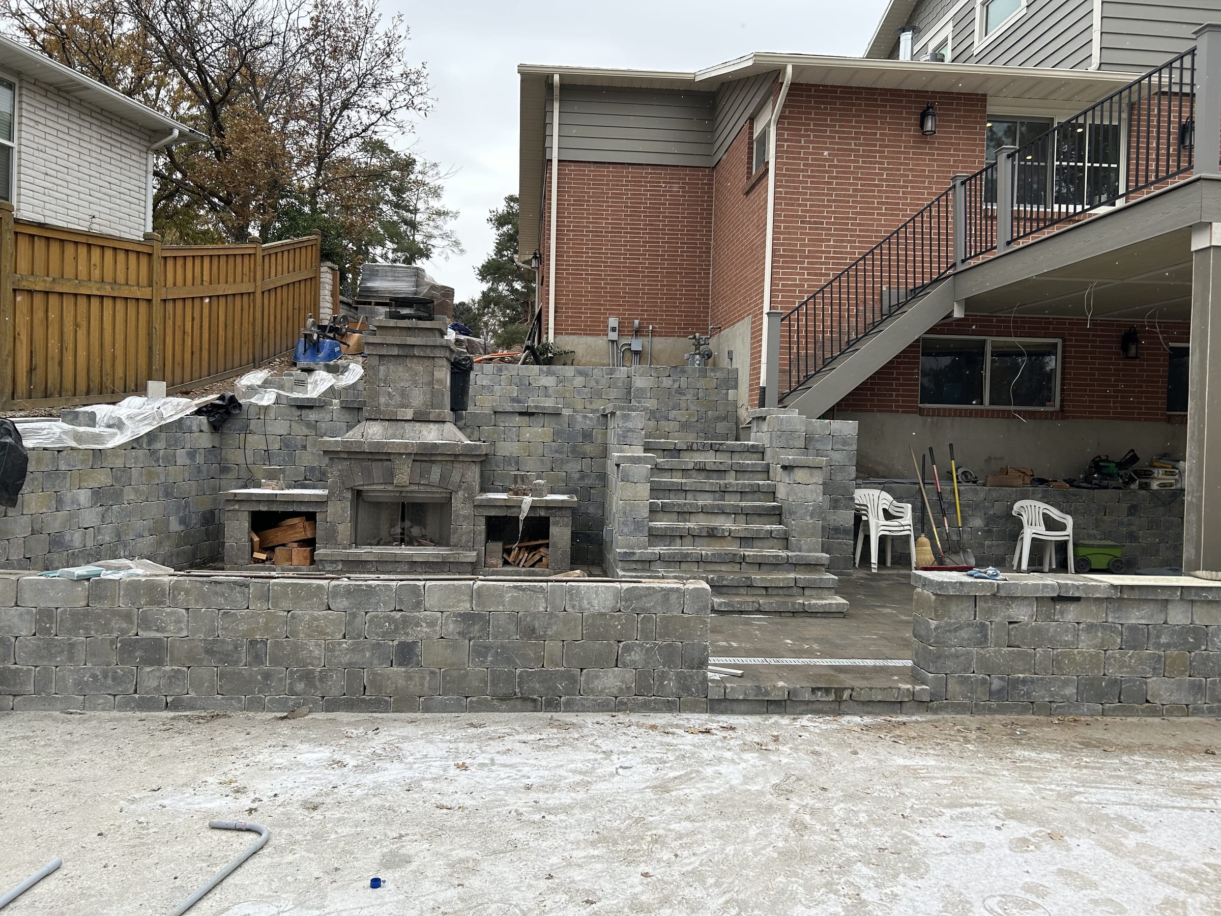 Stone outdoor fireplace and stone retaining walls with stairs